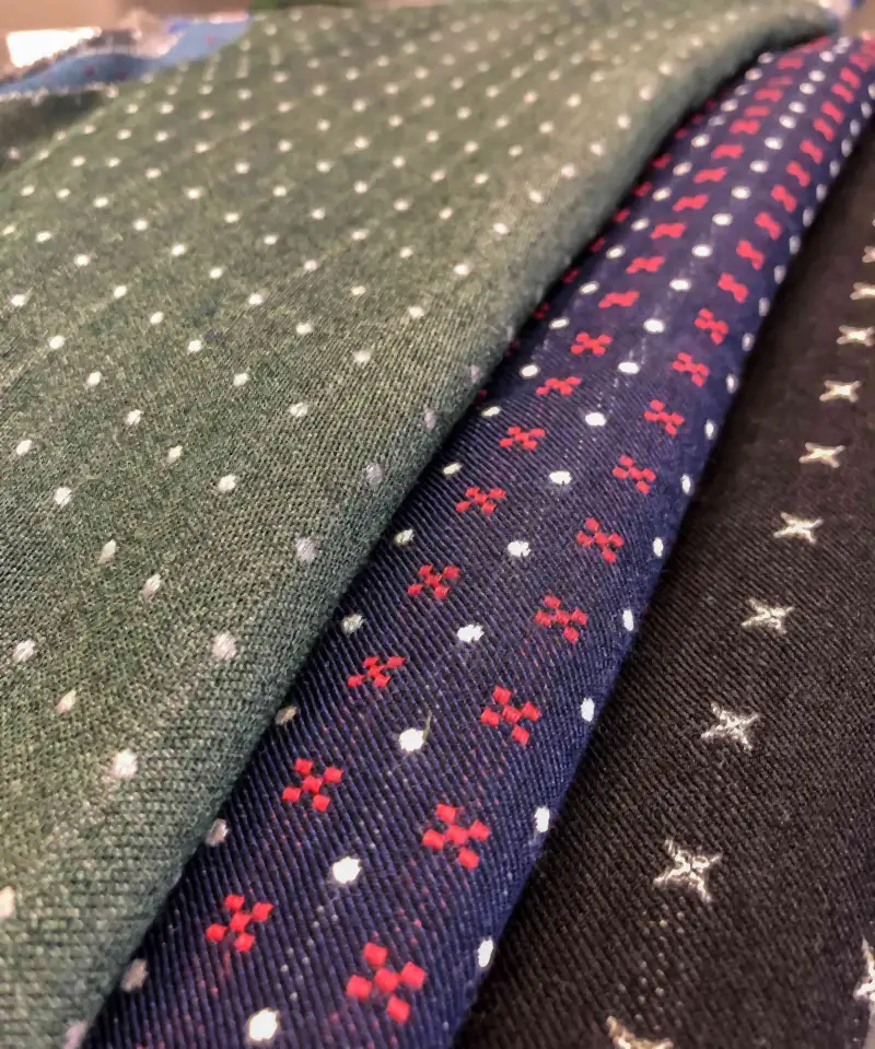 Tessuti da cravatta in seta a pois e a fiori, uno accanto all’altro