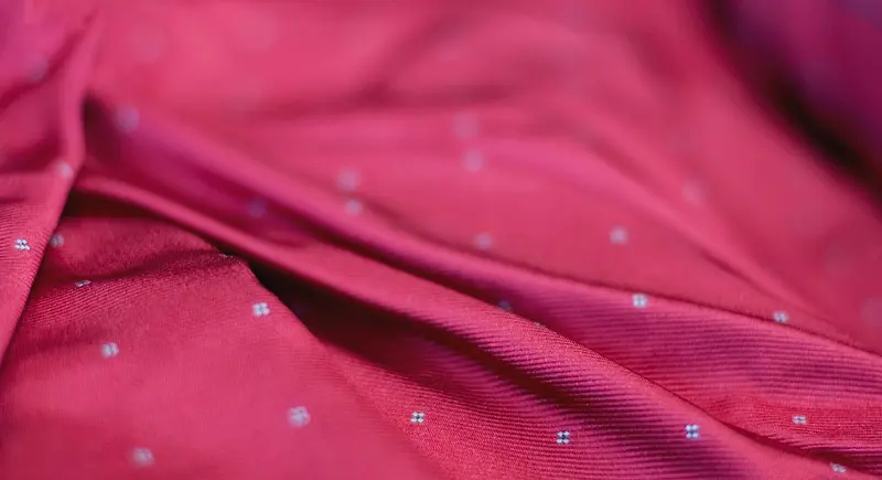 Primo piano di una seta da cravatta fucsia a piccoli disegni